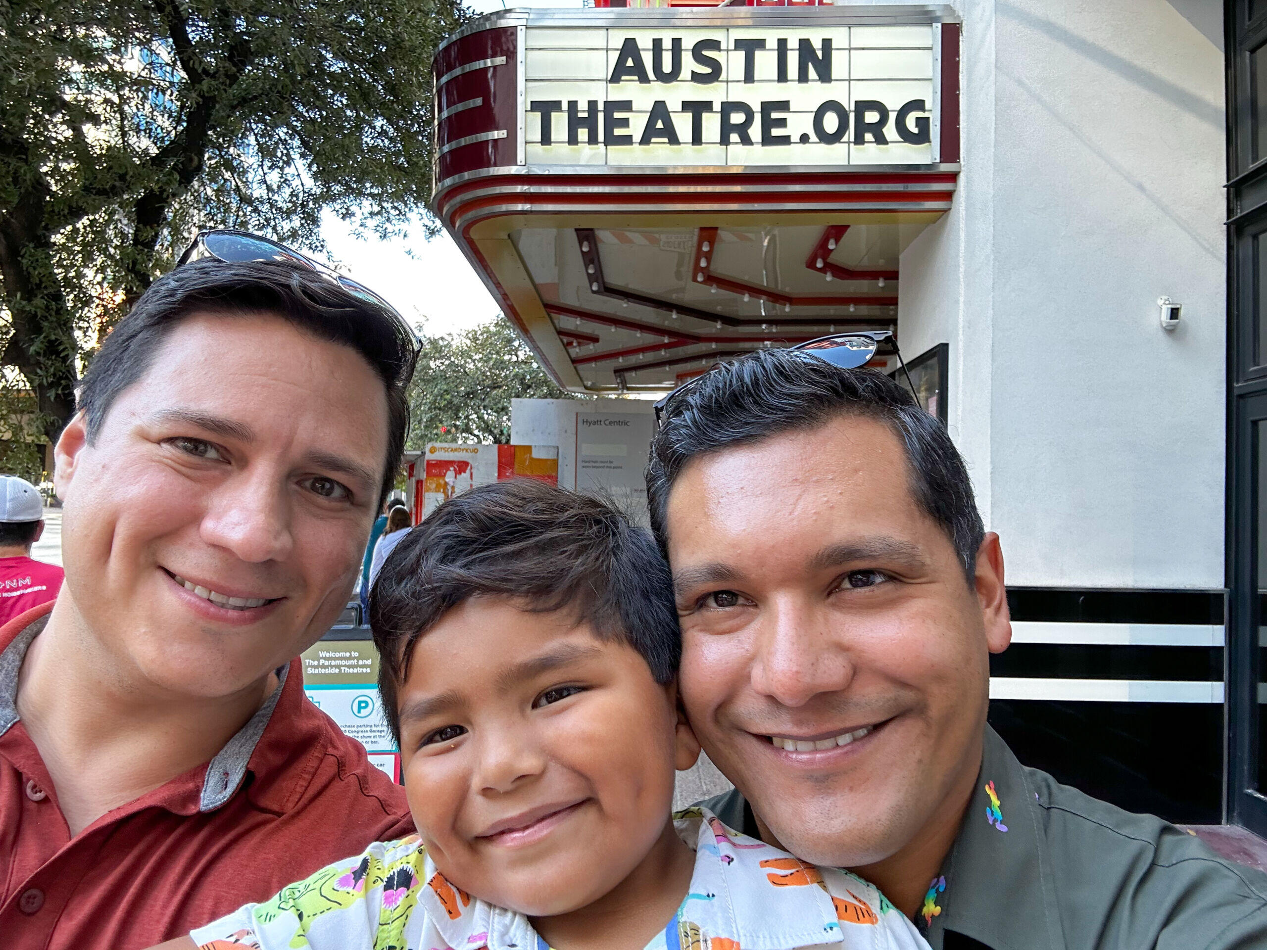 Hispanic adoptive parents with adopted son outside a theater in Austin, TX