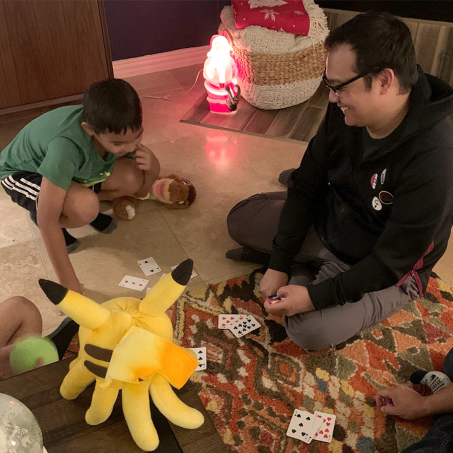 White adoptive dad playing cards with young male family member