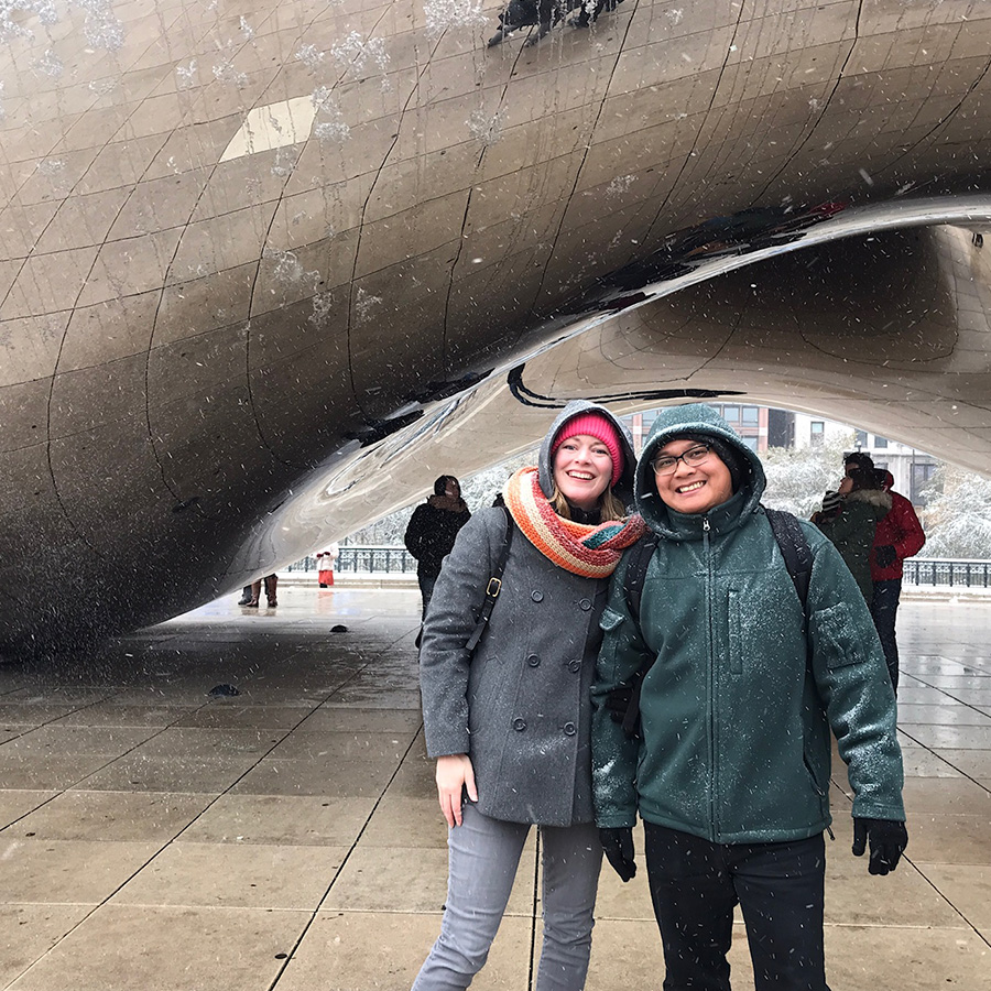 Adoptive dads on vacation wearing raincoats and smiling