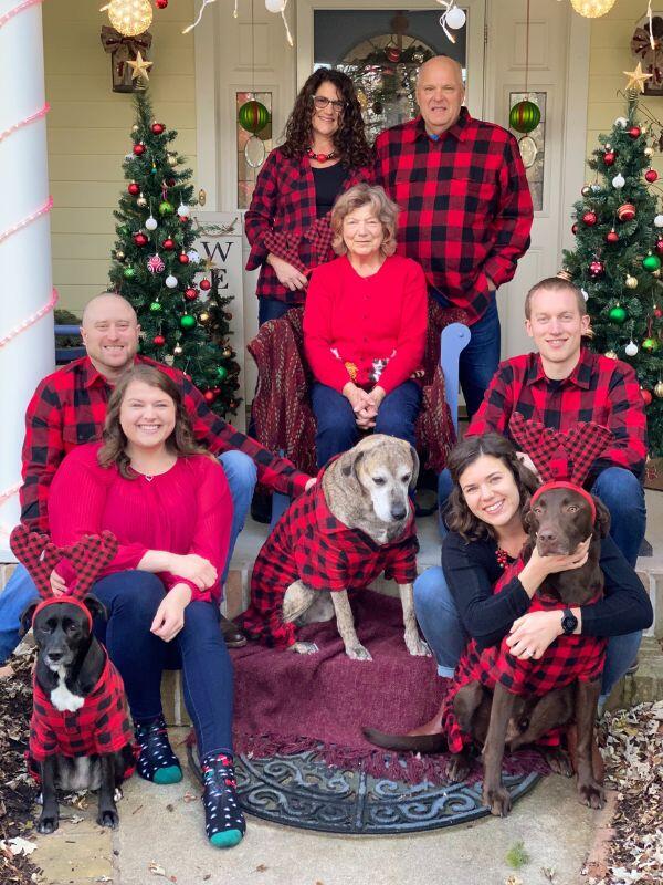 Prospective adoptive couple with extended family in matching red paid shirts