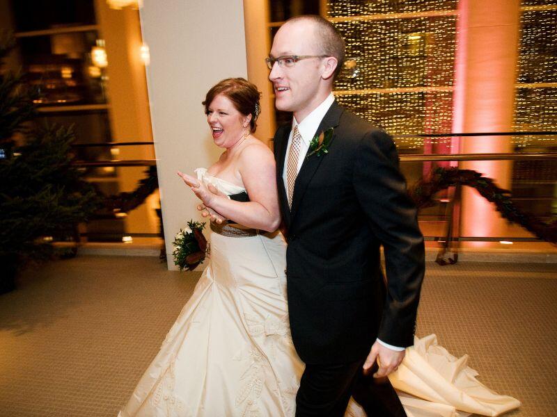 Rachel in a strapless wedding dress and Jason in a suit, smiling at their wedding