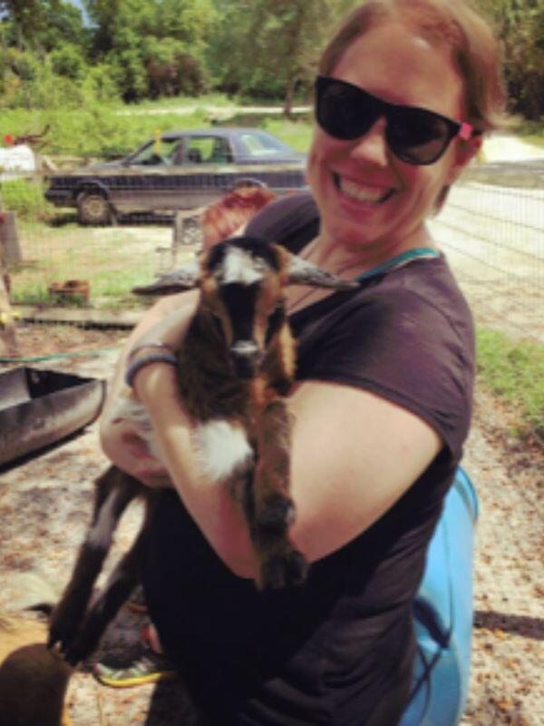 White adoptive mom holding a baby goat