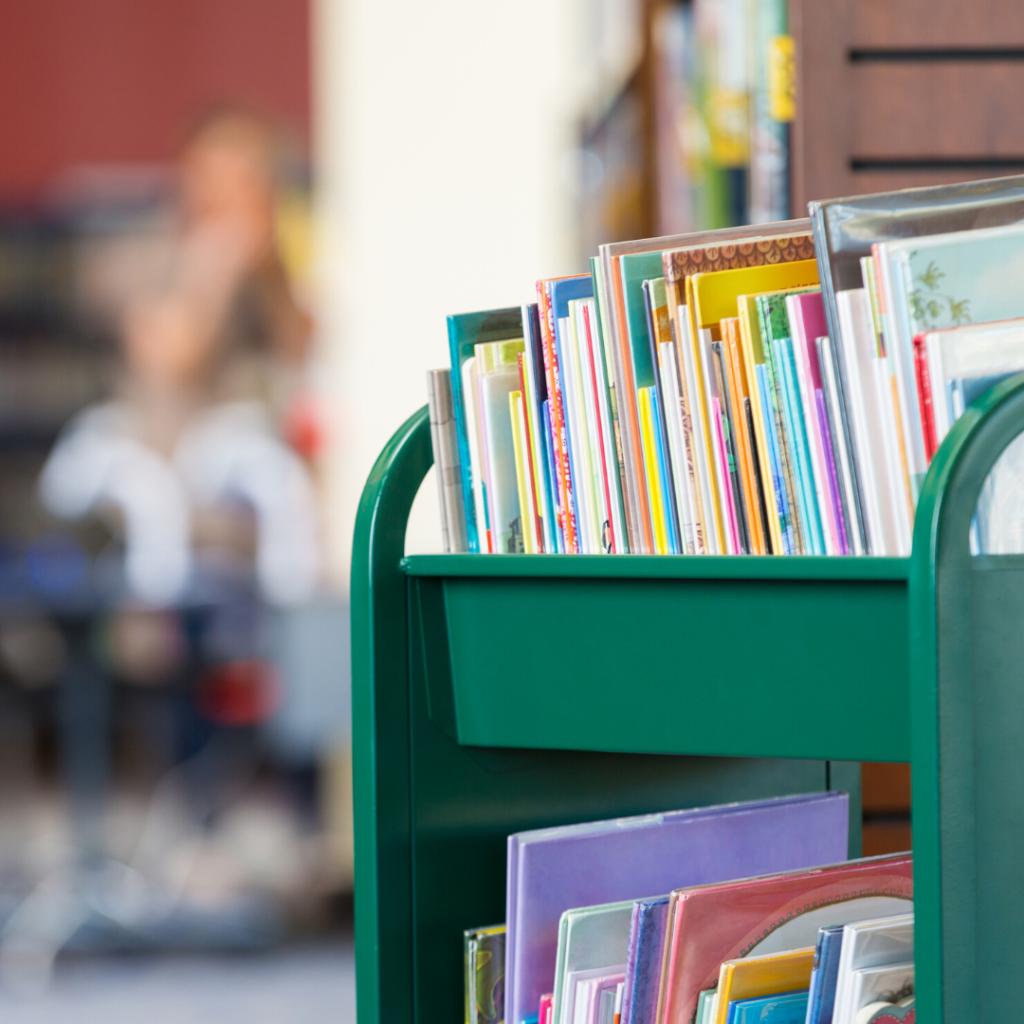 Library book cart with picture books about adoption