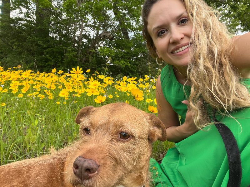 Adoptive mom in a field with her terrier Fira