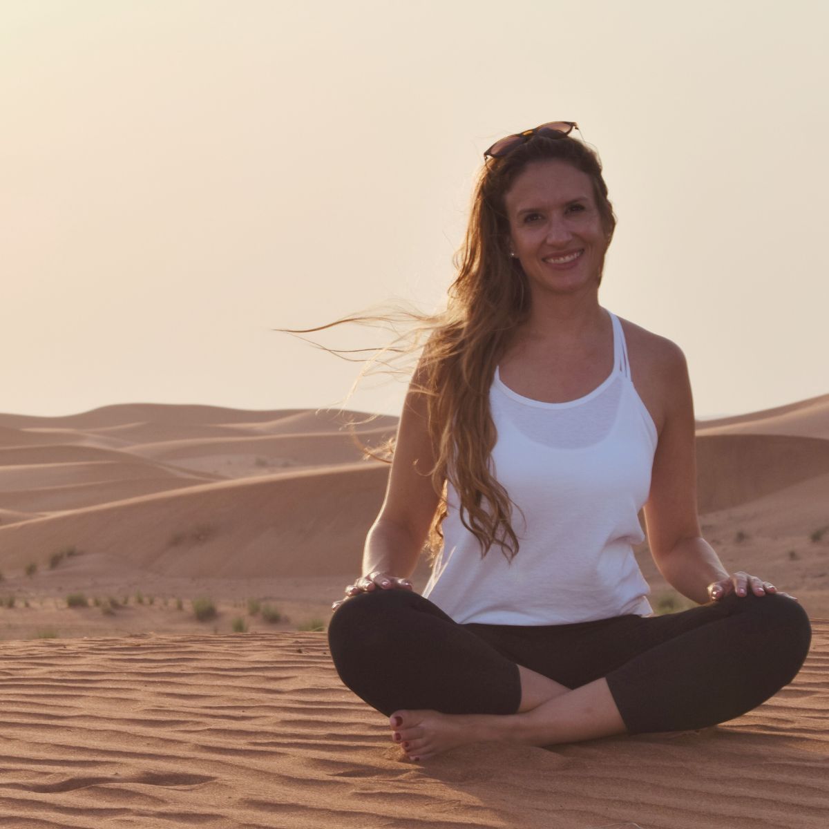 White adoptive mom doing yoga on the sand at sunset