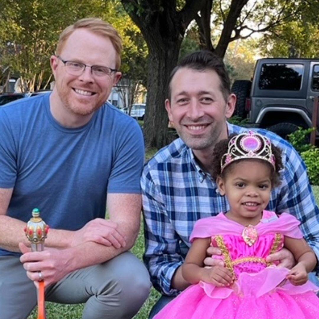 Brad and Buddy, white LGBT adoptive parents in Dallas, with their black daughter
