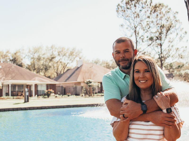 Adoptive parents Ben and Laci by an outdoor pool