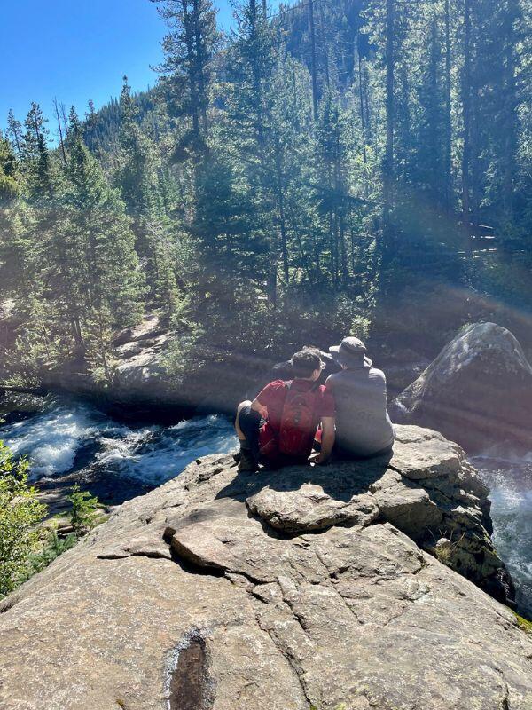 Nature loving adoptive couple from houston sitting by a lake in the mountains