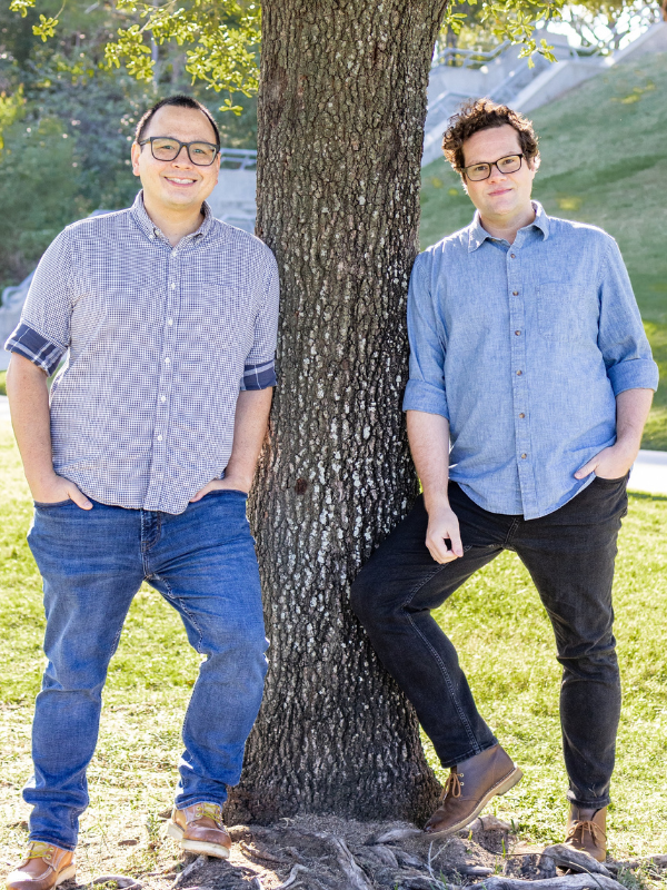 Gay adoptive couple leaning against tree in Houston park