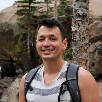 Houston adoptive dad Daniel, hiking in the mountains with tank top and backpack