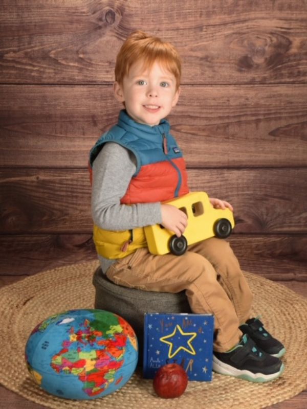 Red-headed boy posing with toys in portrait photo