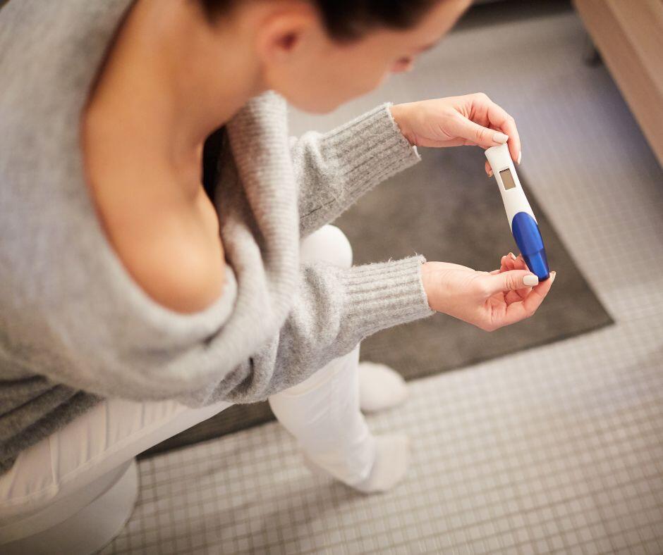 woman looking at pregnancy test