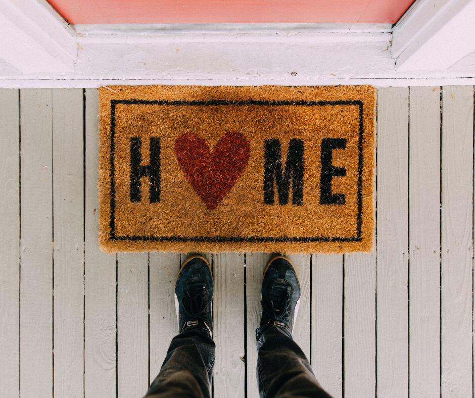 welcome mat that says Home at front door